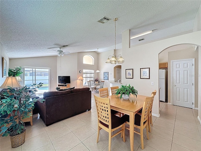 2649 Hemingway Ave, Haines City, FL 33844 - dining space featuring arched walkways, light tile patterned floors, ceiling fan, vaulted ceiling, and a textured ceiling