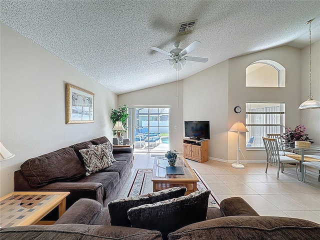 2649 Hemingway Ave, Haines City, FL 33844 - living room with lofted ceiling, light tile patterned floors, a ceiling fan, and a textured ceiling