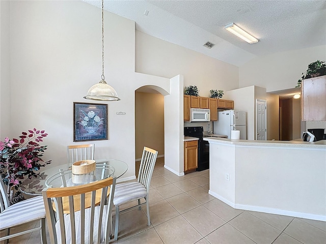2649 Hemingway Ave, Haines City, FL 33844 - kitchen with white appliances, high vaulted ceiling, arched walkways, light tile patterned flooring, and brown cabinetry