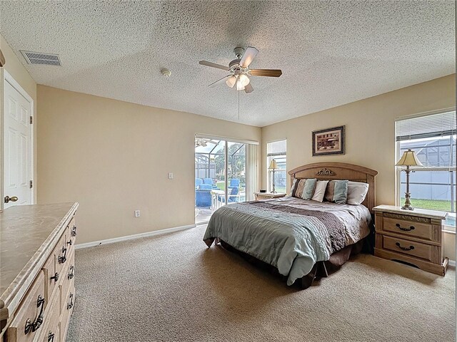 2649 Hemingway Ave, Haines City, FL 33844 - bedroom featuring access to exterior, light carpet, a textured ceiling, and ceiling fan