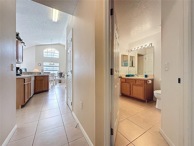 2649 Hemingway Ave, Haines City, FL 33844 - bathroom featuring a textured ceiling, tile patterned floors, vanity, and lofted ceiling