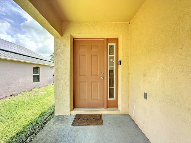 2649 Hemingway Ave, Haines City, FL 33844 - view of exterior entry with stucco siding and a lawn