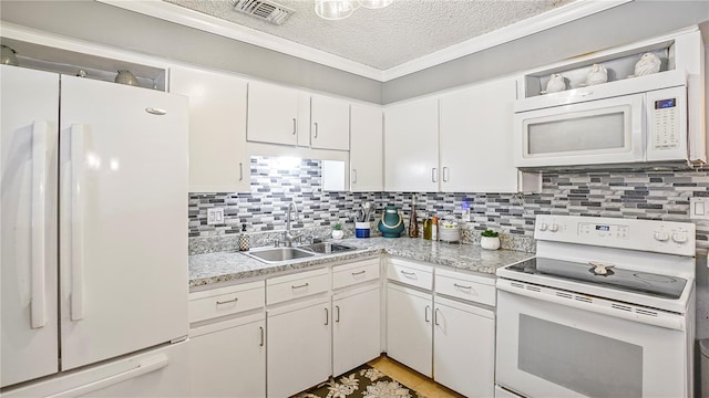 505 Oak Dr, Tavares, FL 32778 - kitchen featuring white appliances, light countertops, a textured ceiling, white cabinets, and tasteful backsplash