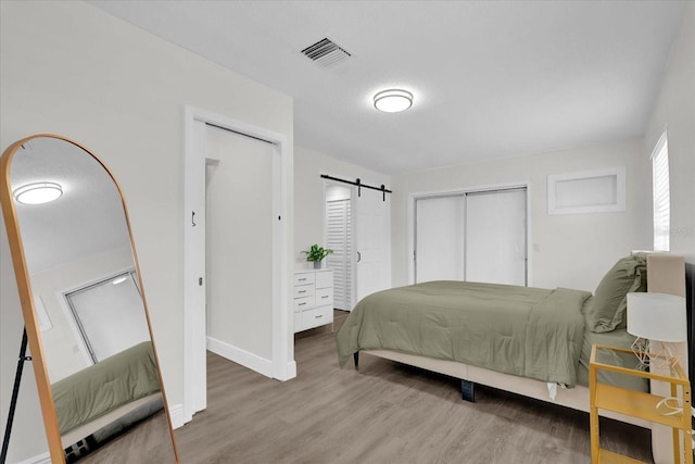 1501 Missouri Ave, Saint Cloud, FL 34769 - bedroom featuring wood finished floors, a barn door, and a closet