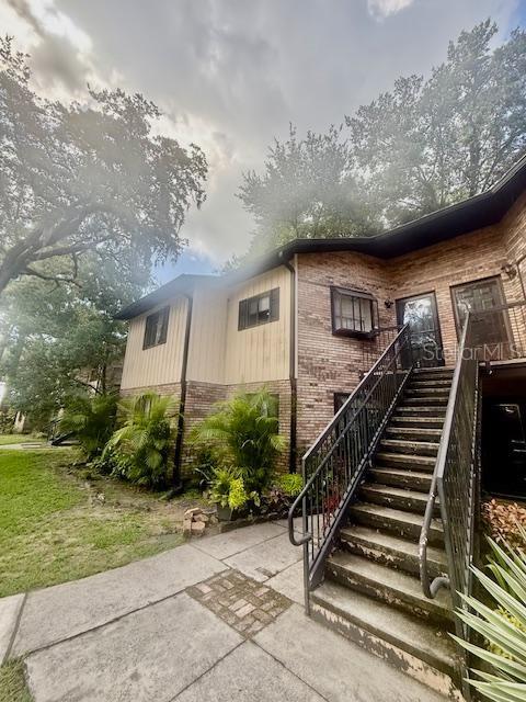 1720 Foxhall Cir Unit 1720, Kissimmee, FL 34741 - property entrance with brick siding and a patio