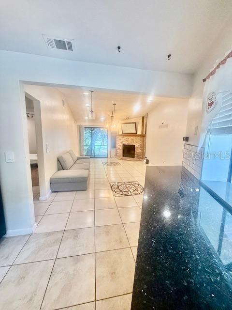1720 Foxhall Cir Unit 1720, Kissimmee, FL 34741 - unfurnished living room featuring light tile patterned floors and a fireplace