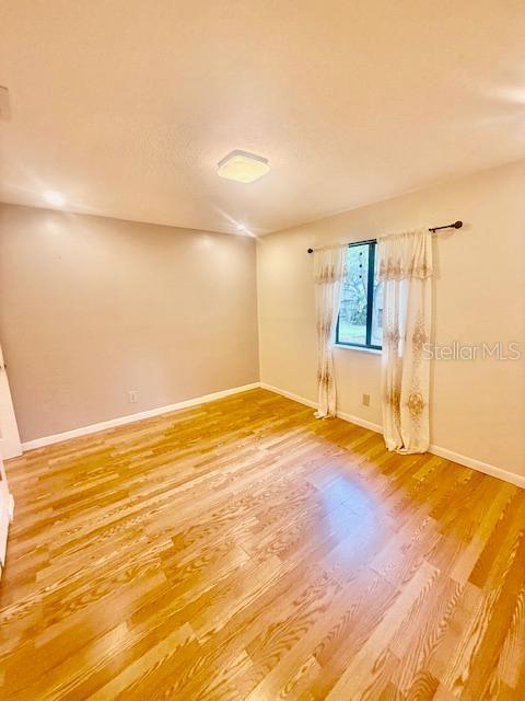 1720 Foxhall Cir Unit 1720, Kissimmee, FL 34741 - empty room featuring light wood-style flooring and baseboards