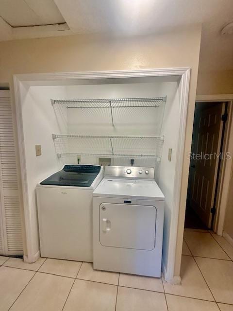 1720 Foxhall Cir Unit 1720, Kissimmee, FL 34741 - laundry room with washer and clothes dryer and light tile patterned floors