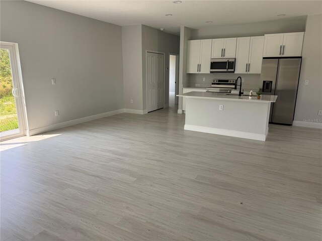 21 Pine Course Trak, Ocala, FL 34472 - kitchen with appliances with stainless steel finishes, light countertops, light wood-style flooring, and an island with sink