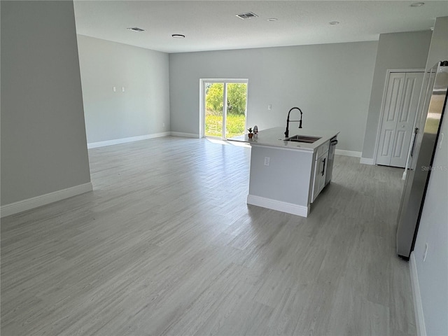 21 Pine Course Trak, Ocala, FL 34472 - kitchen with light wood-style floors, a kitchen island with sink, open floor plan, and white cabinets