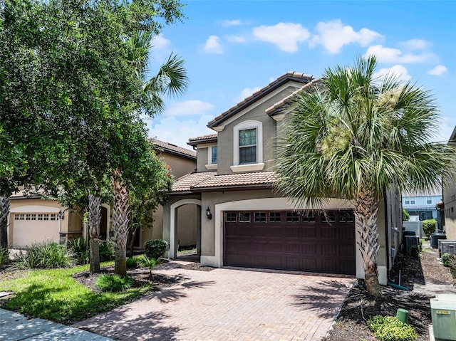 8897 Rhodes St, Kissimmee, FL 34747 - mediterranean / spanish-style home featuring decorative driveway, a tile roof, a garage, and stucco siding