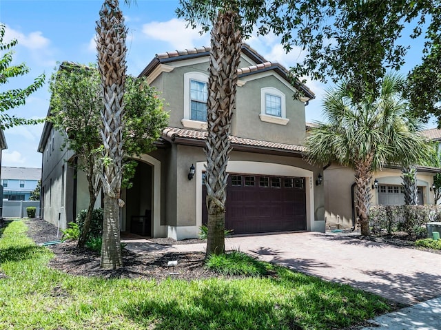 8897 Rhodes St, Kissimmee, FL 34747 - mediterranean / spanish-style house with an attached garage, stucco siding, a tiled roof, and driveway