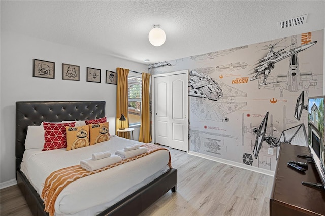 8897 Rhodes St, Kissimmee, FL 34747 - bedroom featuring light wood-type flooring, a textured ceiling, and a closet