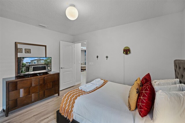8897 Rhodes St, Kissimmee, FL 34747 - bedroom featuring light wood finished floors and a textured ceiling
