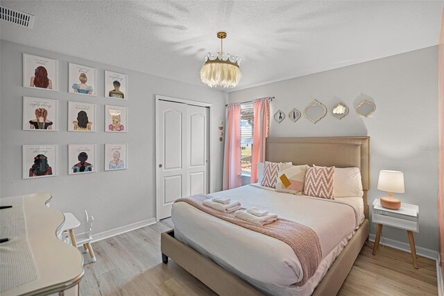 8897 Rhodes St, Kissimmee, FL 34747 - bedroom with a chandelier, a closet, light wood-style floors, and a textured ceiling