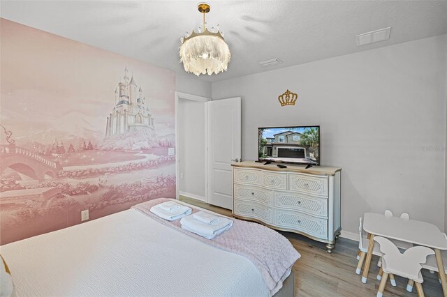 8897 Rhodes St, Kissimmee, FL 34747 - bedroom featuring wood finished floors and a chandelier