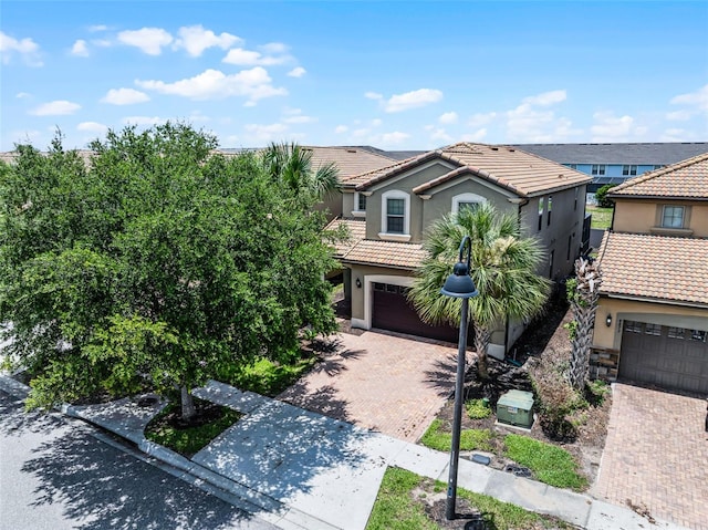 8897 Rhodes St, Kissimmee, FL 34747 - view of front of property with a tiled roof, decorative driveway, stucco siding, and a garage