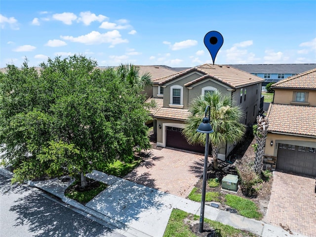 8897 Rhodes St, Kissimmee, FL 34747 - view of front of property featuring a tiled roof, decorative driveway, stucco siding, and an attached garage