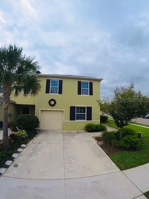 403 Arbor Lakes Dr, Davenport, FL 33896 - view of front of home with a garage, stucco siding, and driveway