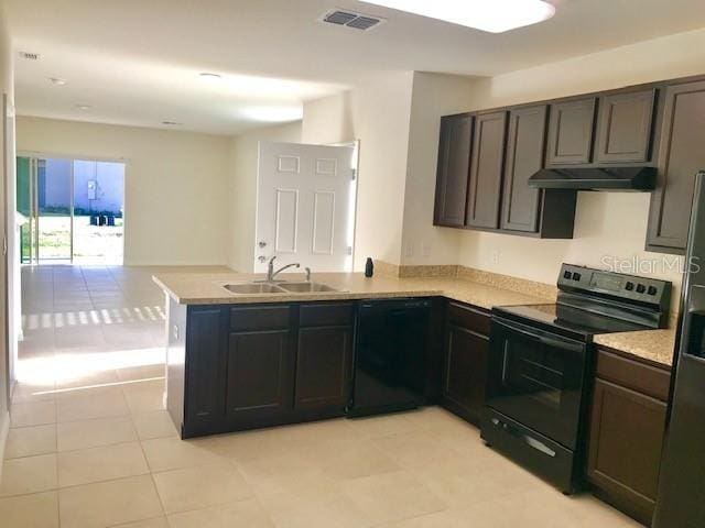 403 Arbor Lakes Dr, Davenport, FL 33896 - kitchen featuring black appliances, under cabinet range hood, a peninsula, light countertops, and open floor plan