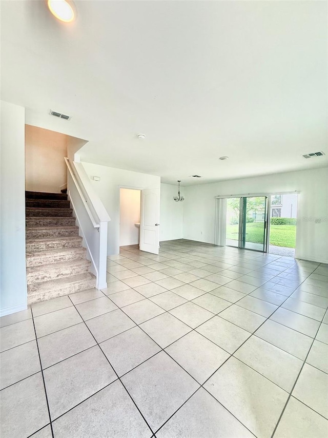 403 Arbor Lakes Dr, Davenport, FL 33896 - unfurnished living room with light tile patterned flooring and stairway