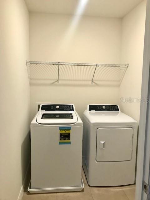 403 Arbor Lakes Dr, Davenport, FL 33896 - washroom with washing machine and clothes dryer and light tile patterned floors