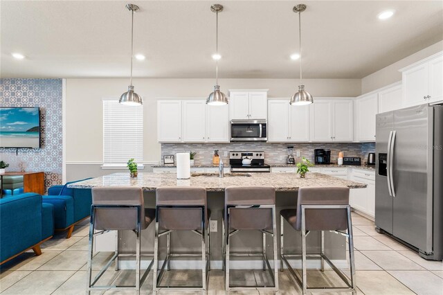 2161 Lelani Cir, Davenport, FL 33897 - kitchen with appliances with stainless steel finishes, a kitchen breakfast bar, light stone countertops, white cabinetry, and recessed lighting