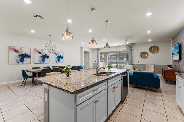 2161 Lelani Cir, Davenport, FL 33897 - kitchen with open floor plan, light tile patterned floors, light stone counters, a center island with sink, and recessed lighting