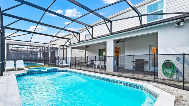 2161 Lelani Cir, Davenport, FL 33897 - view of pool featuring a patio area, glass enclosure, a pool with connected hot tub, a ceiling fan, and outdoor dining area