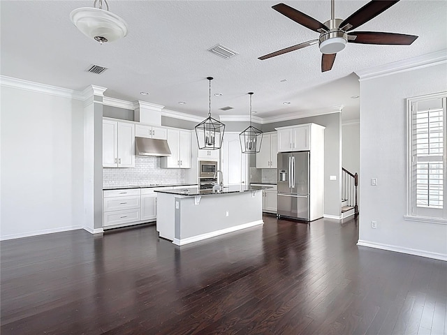 1513 Resolute St, Celebration, FL 34747 - kitchen featuring appliances with stainless steel finishes, under cabinet range hood, a ceiling fan, dark wood finished floors, and backsplash