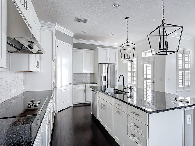1513 Resolute St, Celebration, FL 34747 - kitchen featuring under cabinet range hood, appliances with stainless steel finishes, ornamental molding, a kitchen island with sink, and white cabinets