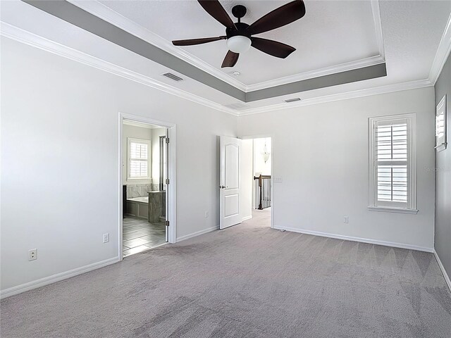 1513 Resolute St, Celebration, FL 34747 - unfurnished bedroom with a tray ceiling, carpet, ornamental molding, ensuite bath, and a ceiling fan