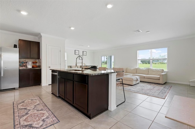 3255 Hilltop Cir, Bradenton, FL 34211 - kitchen featuring stainless steel appliances, healthy amount of natural light, crown molding, a breakfast bar, and dark brown cabinets