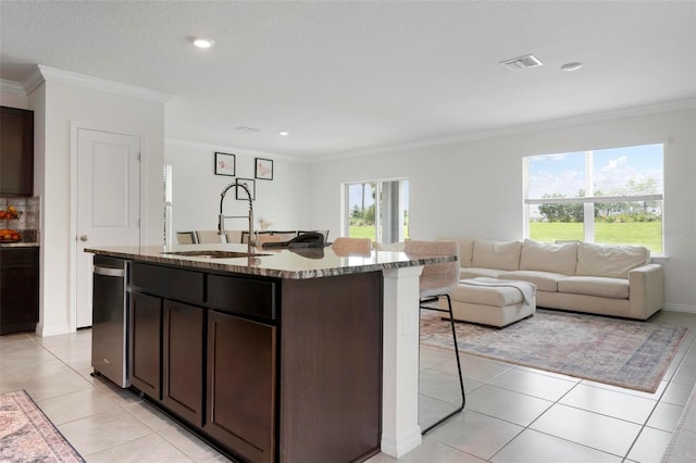 3255 Hilltop Cir, Bradenton, FL 34211 - kitchen with a breakfast bar area, open floor plan, dark brown cabinets, crown molding, and a center island with sink