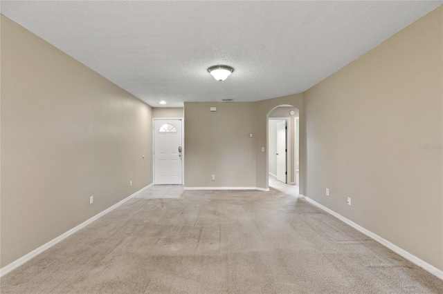 2832 Osprey Cove Pl Unit 102, Kissimmee, FL 34746 - spare room with arched walkways, a textured ceiling, and light colored carpet