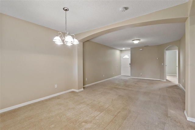 2832 Osprey Cove Pl Unit 102, Kissimmee, FL 34746 - spare room with arched walkways, light colored carpet, a chandelier, a smoke detector, and a textured ceiling
