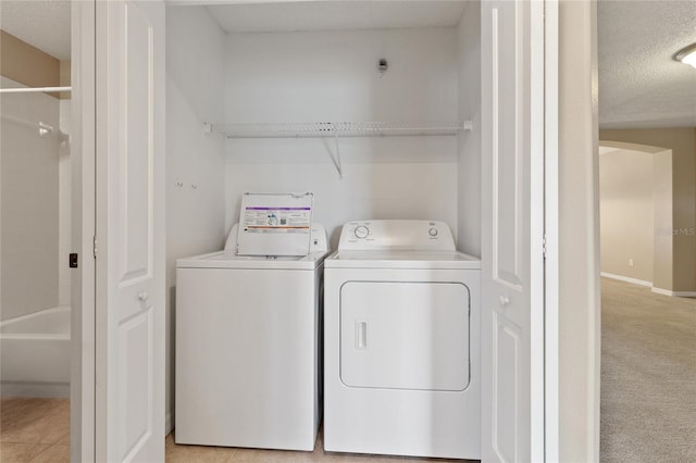 2832 Osprey Cove Pl Unit 102, Kissimmee, FL 34746 - washroom with washer and clothes dryer and a textured ceiling