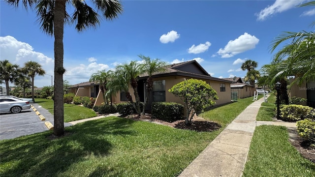 2326 St Marteen Ct, Kissimmee, FL 34741 - view of front of property featuring a front yard, stucco siding, and uncovered parking