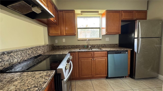 2326 St Marteen Ct, Kissimmee, FL 34741 - kitchen with dishwashing machine, wall chimney exhaust hood, electric stove, freestanding refrigerator, and brown cabinets