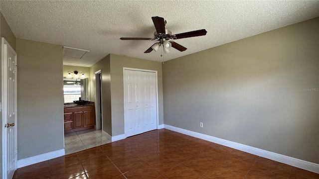 2326 St Marteen Ct, Kissimmee, FL 34741 - unfurnished bedroom featuring tile patterned floors, a closet, a textured ceiling, connected bathroom, and a ceiling fan
