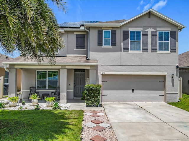 209 Willow Bend Dr, Davenport, FL 33897 - view of front facade featuring a porch, stucco siding, driveway, solar panels, and an attached garage
