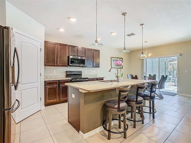 209 Willow Bend Dr, Davenport, FL 33897 - kitchen with appliances with stainless steel finishes, light tile patterned flooring, a kitchen breakfast bar, pendant lighting, and recessed lighting