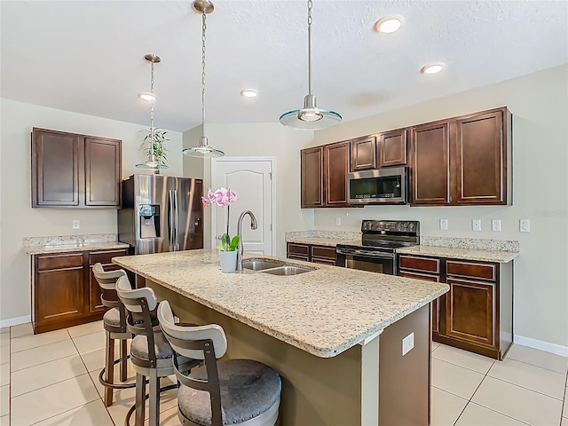 209 Willow Bend Dr, Davenport, FL 33897 - kitchen featuring stainless steel appliances, light tile patterned floors, a breakfast bar, a center island with sink, and recessed lighting