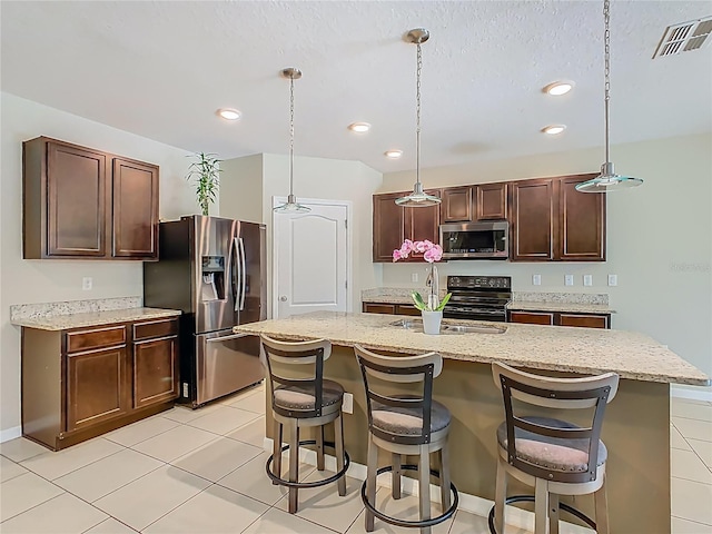 209 Willow Bend Dr, Davenport, FL 33897 - kitchen with stainless steel appliances, a breakfast bar area, recessed lighting, pendant lighting, and light stone countertops