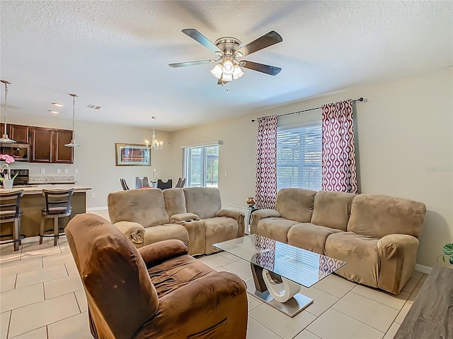 209 Willow Bend Dr, Davenport, FL 33897 - living area with ceiling fan, a chandelier, light tile patterned floors, and a textured ceiling