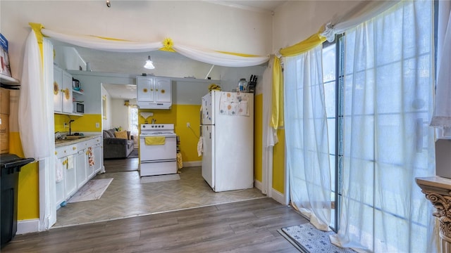 1431 Jack Calhoun Dr, Kissimmee, FL 34741 - kitchen featuring white appliances, white cabinets, healthy amount of natural light, and light countertops