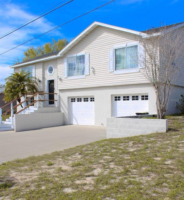 4151 Nelson Rd, Lake Wales, FL 33898 - bi-level home featuring a garage, driveway, and stucco siding