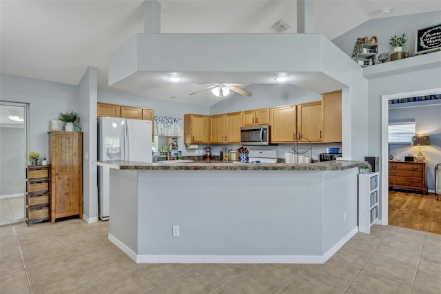 6396 Bennett Ct, Saint Cloud, FL 34771 - kitchen featuring stainless steel microwave, vaulted ceiling, white fridge with ice dispenser, light tile patterned floors, and a ceiling fan
