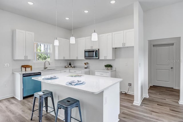4410 Vicky St, Hastings, FL 32145 - kitchen featuring dishwashing machine, stainless steel microwave, a breakfast bar, a center island, and light wood-type flooring
