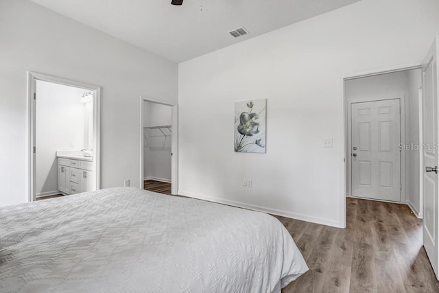 4410 Vicky St, Hastings, FL 32145 - bedroom featuring wood finished floors, a spacious closet, connected bathroom, a closet, and a ceiling fan